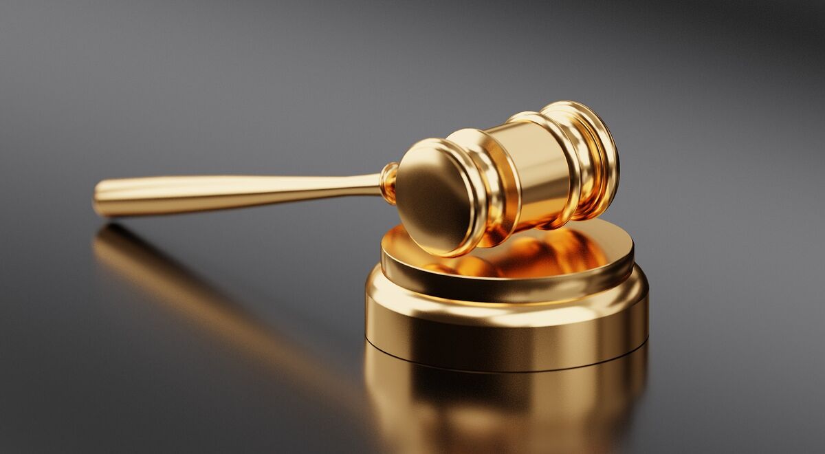 Estante de livros jurídicos com estatueta da Justiça, representando a tradição da advocacia